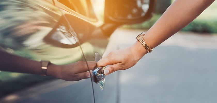 Sieviete taisa vaļā durvis auto kredītā paņemtajai automašīnai.