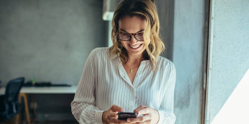 Sieviete lieto eParakstu savā telefonā, lai parakstītu dokumentus attālināti.