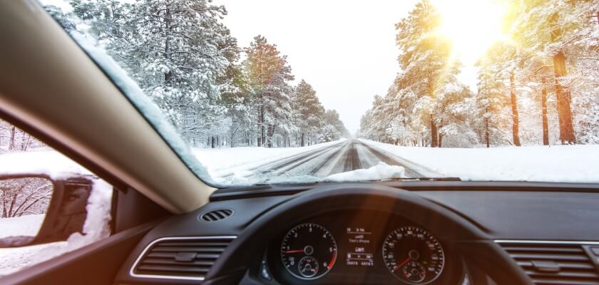 Automašīna brauc ziemā pa sniegotu ceļu