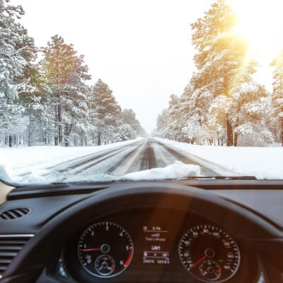 Automašīna brauc ziemā pa sniegotu ceļu