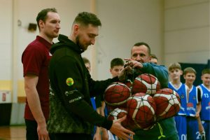 Artūrs Ilziņš pasniedz basketbola bumbas sporta skolai