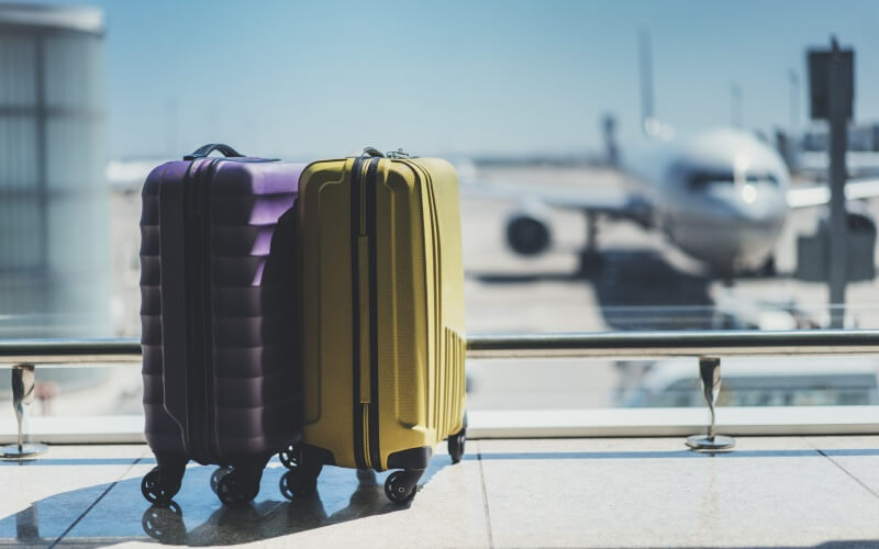 Разноцветные чемоданы у окна в аэропорту